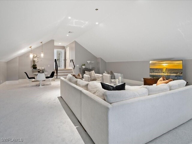 living room with light carpet, lofted ceiling, and a chandelier