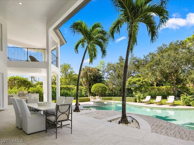 view of swimming pool with a pool with connected hot tub, outdoor dining area, area for grilling, and a patio
