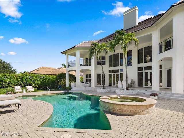 view of pool featuring a patio, french doors, and a pool with connected hot tub