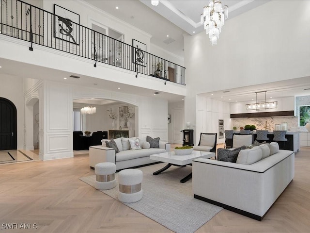 living room featuring visible vents, arched walkways, a notable chandelier, and recessed lighting
