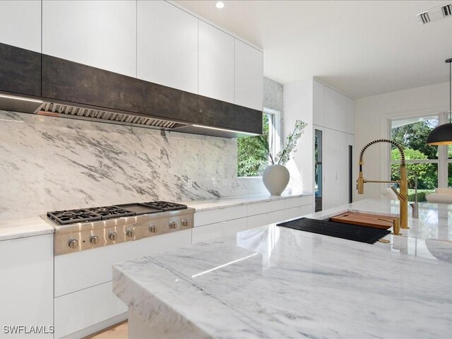 kitchen with hanging light fixtures, sink, white cabinetry, ventilation hood, and stainless steel gas stovetop