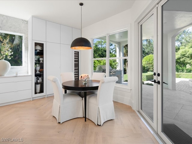 dining room featuring a wealth of natural light, light parquet flooring, and french doors