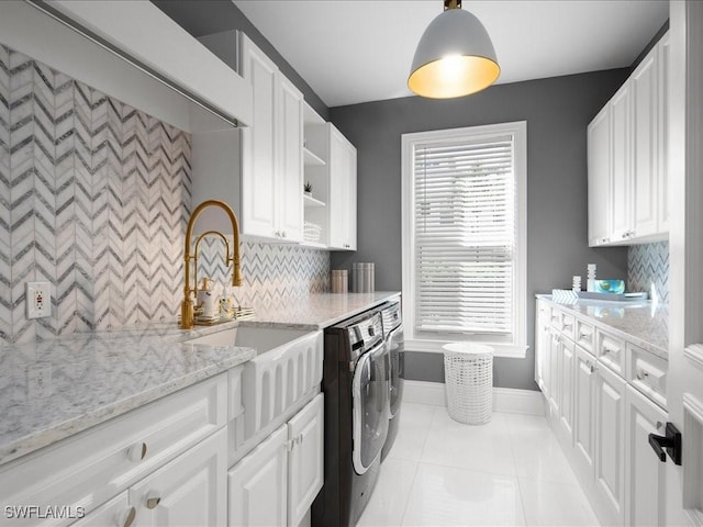 kitchen featuring decorative backsplash, white cabinetry, a sink, separate washer and dryer, and light tile patterned floors