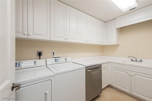 clothes washing area featuring independent washer and dryer, sink, and cabinets