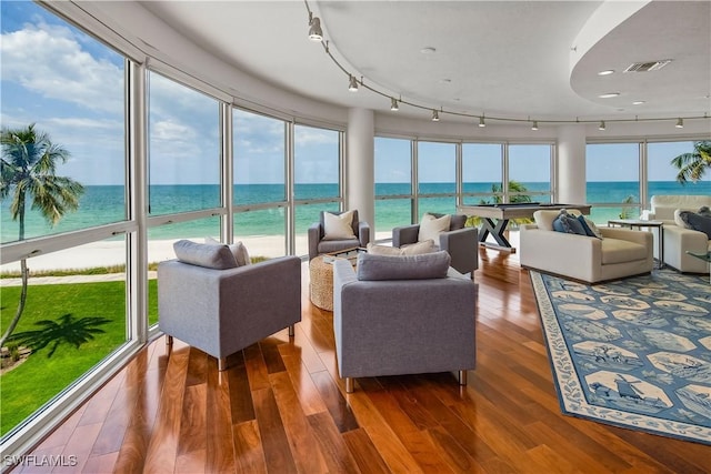 sunroom featuring a water view