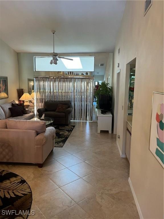 living area featuring a ceiling fan and light tile patterned flooring