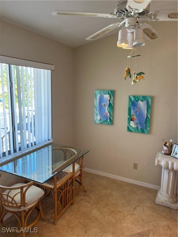 dining space with a ceiling fan and baseboards