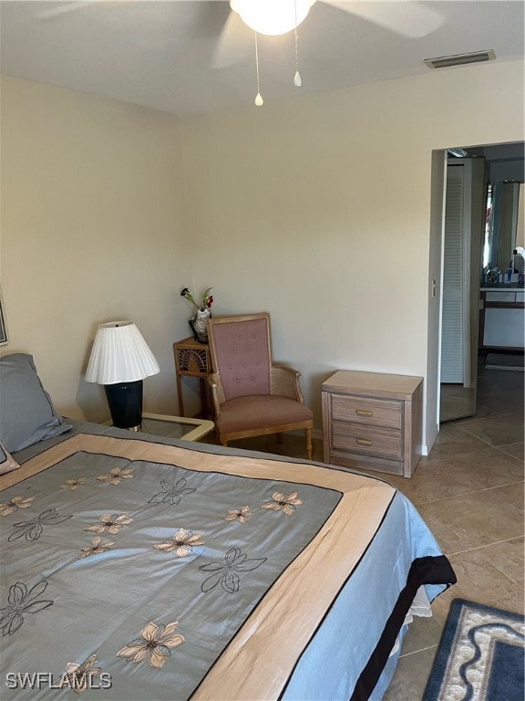 tiled bedroom featuring ceiling fan