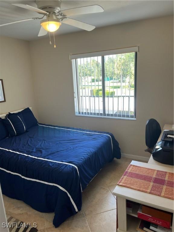 tiled bedroom with multiple windows and a ceiling fan