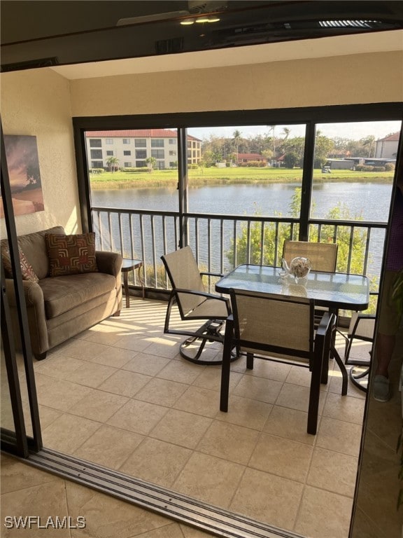 sunroom featuring a water view