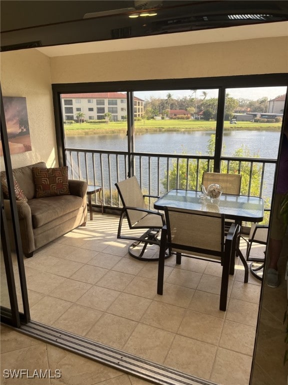 sunroom / solarium featuring a water view