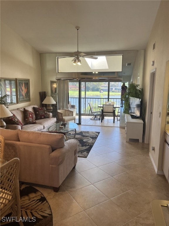 tiled living room with a skylight and ceiling fan