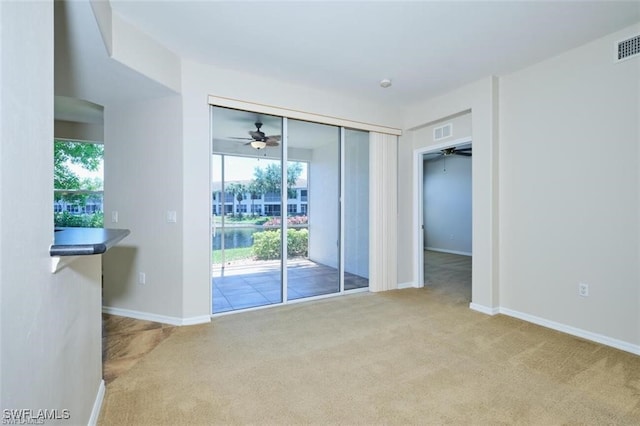 spare room featuring ceiling fan and light carpet