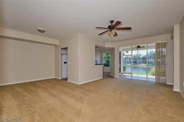 spare room featuring light carpet and ceiling fan