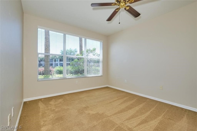 spare room featuring ceiling fan, light colored carpet, and plenty of natural light