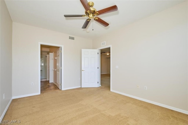 unfurnished bedroom featuring light carpet, connected bathroom, and ceiling fan