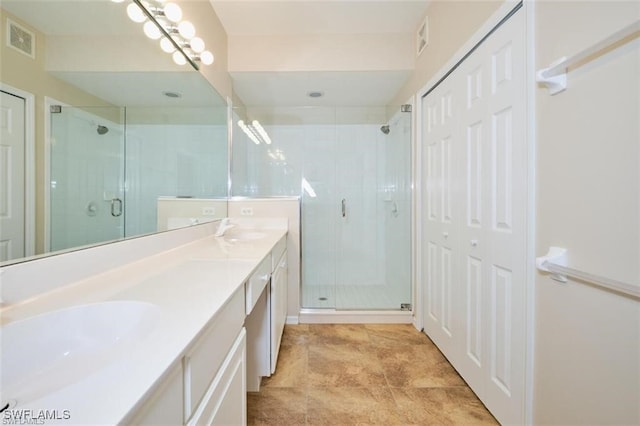 bathroom featuring tile patterned floors, a shower with door, and vanity