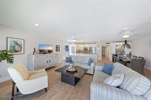 living room featuring light hardwood / wood-style flooring and ceiling fan