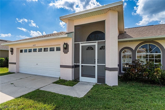 entrance to property featuring a garage and a lawn