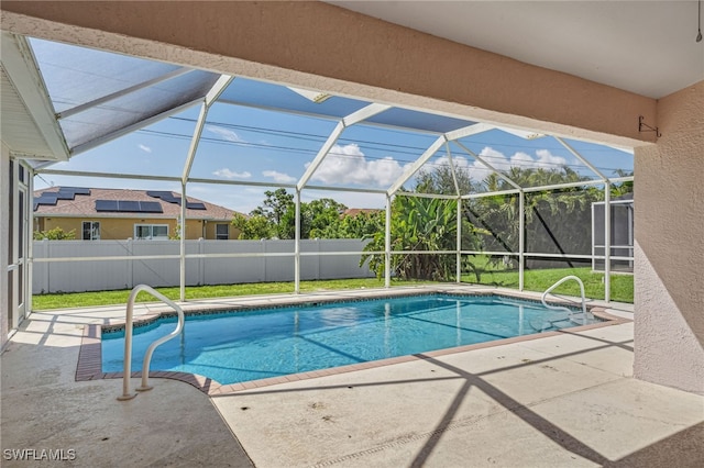 view of pool featuring a yard, glass enclosure, and a patio