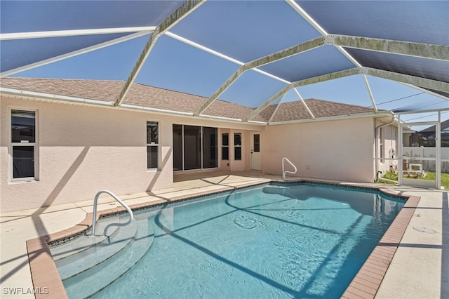 view of swimming pool with glass enclosure and a patio