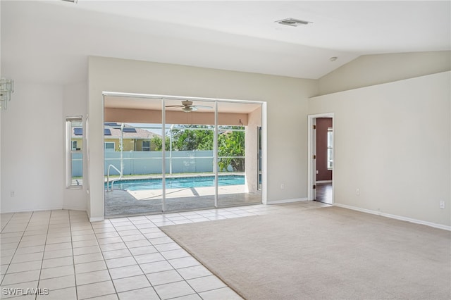 spare room with lofted ceiling and light tile patterned flooring