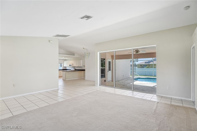 tiled empty room with ceiling fan and lofted ceiling