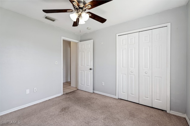 unfurnished bedroom with light carpet, a closet, and ceiling fan