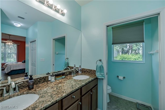 bathroom featuring vanity, toilet, plenty of natural light, and tile patterned flooring