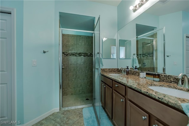 bathroom with vanity, a shower with shower door, and tile patterned floors