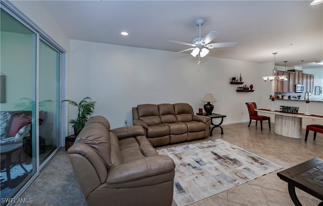 living room featuring light tile patterned floors and ceiling fan with notable chandelier