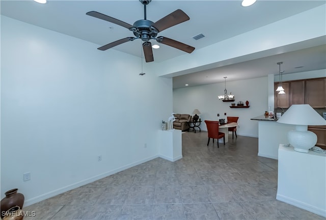 unfurnished living room with ceiling fan with notable chandelier and light tile patterned floors