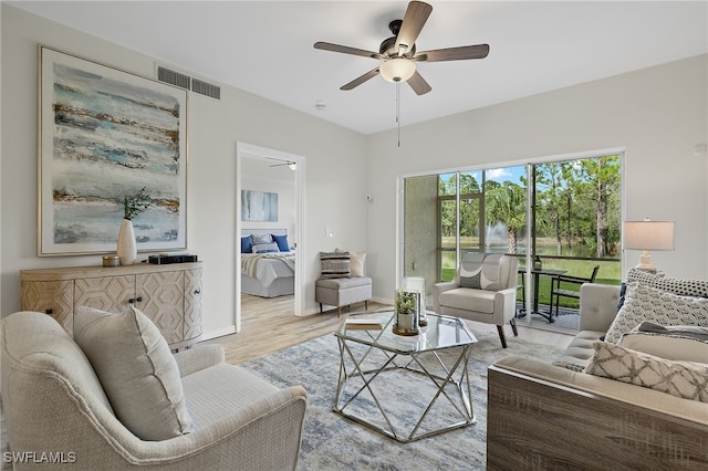 living room with ceiling fan and light hardwood / wood-style flooring