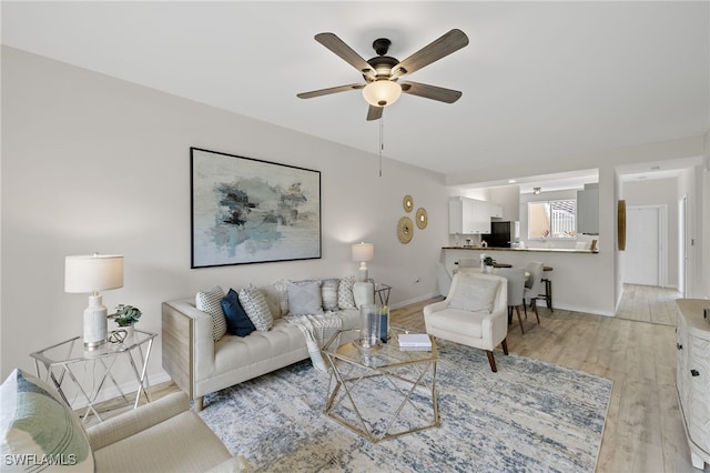 living room featuring ceiling fan and light hardwood / wood-style floors