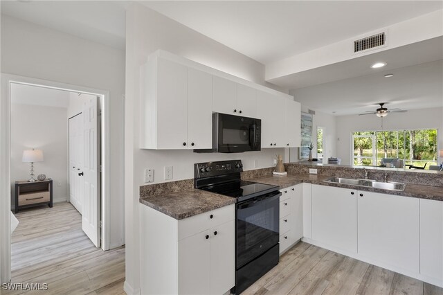 kitchen featuring black appliances, white cabinetry, and sink