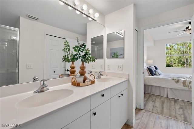 bathroom featuring vanity, wood-type flooring, a shower with shower door, and ceiling fan