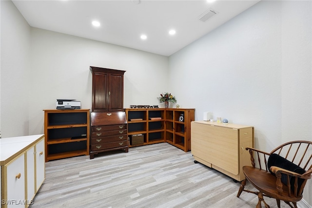 living area with light wood-style flooring, visible vents, and recessed lighting