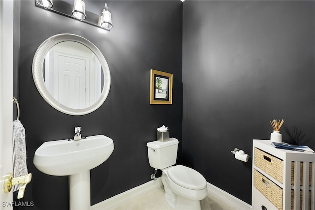 bathroom with toilet and baseboards