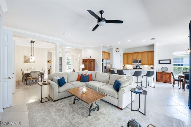 living area featuring ornamental molding, visible vents, decorative columns, and light tile patterned floors