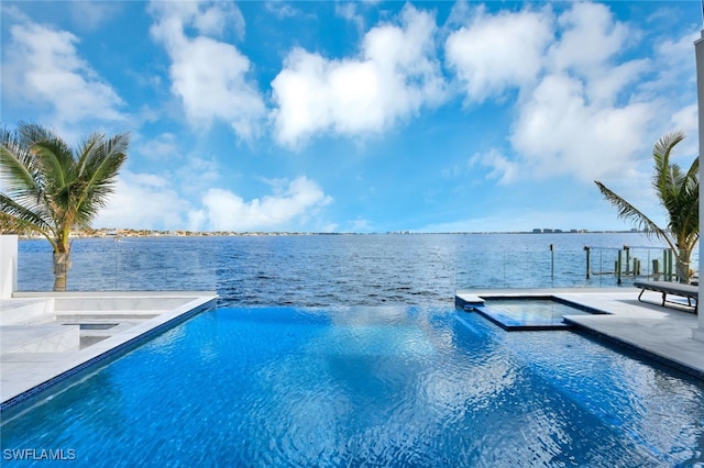 view of swimming pool featuring a patio area, an in ground hot tub, and a water view