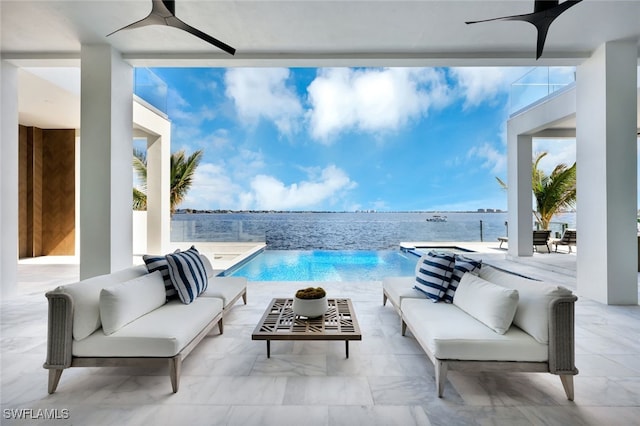 view of pool with a water view, a patio, and an outdoor hangout area