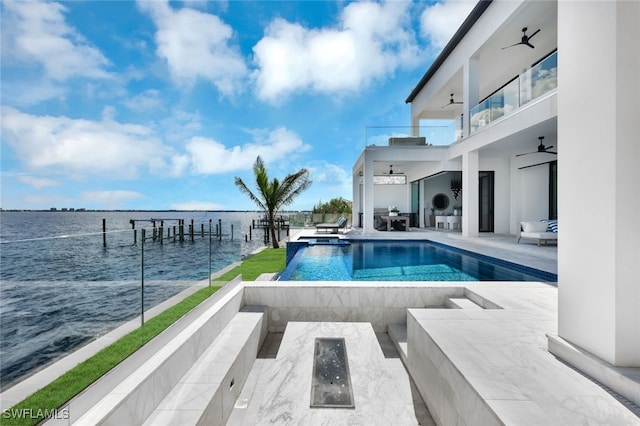 view of pool with ceiling fan, a patio area, a water view, and a dock