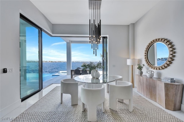 tiled dining room with a water view, an inviting chandelier, and a healthy amount of sunlight