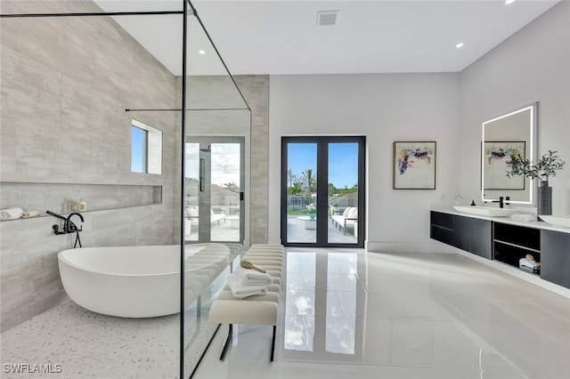 bathroom with tile patterned flooring, vanity, and a tub to relax in