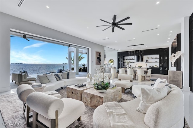 living room with a water view and ceiling fan