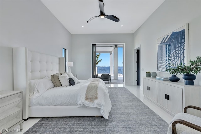 bedroom with access to exterior, ceiling fan, and a water view