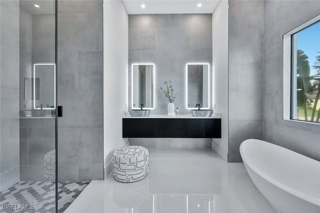 bathroom featuring separate shower and tub, vanity, and tile walls