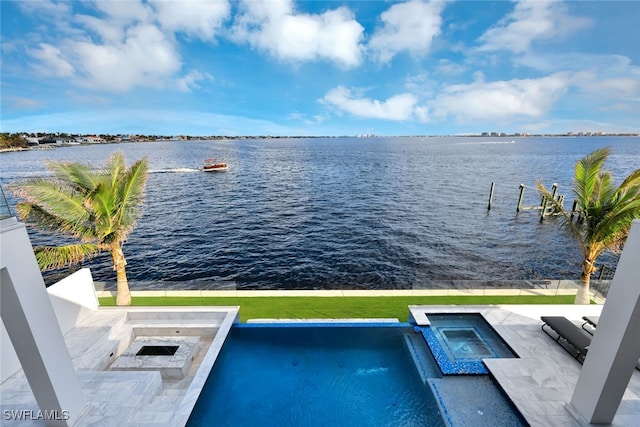 view of swimming pool with a fire pit, a water view, and an in ground hot tub