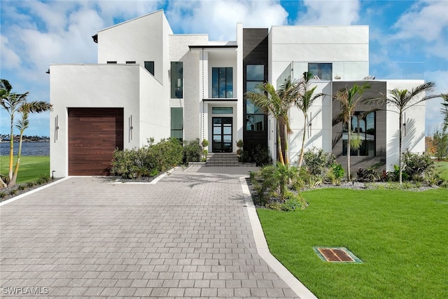 modern home featuring a front yard and a garage