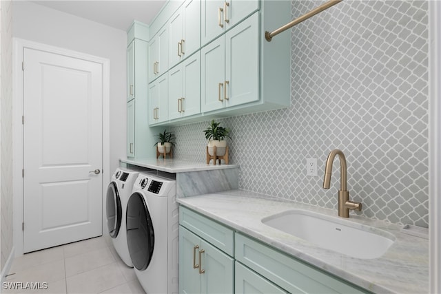 laundry area featuring light tile patterned floors, sink, washer and dryer, and cabinets